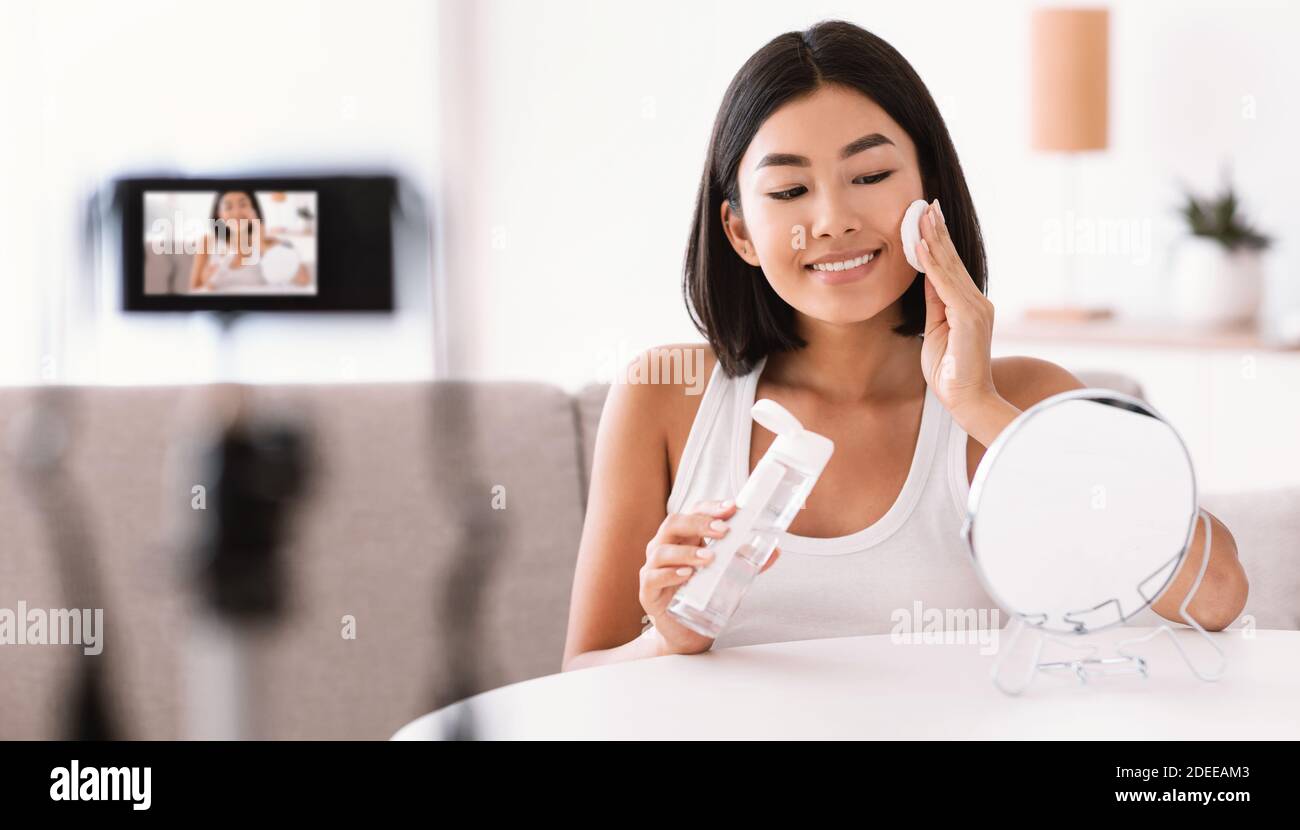 Giovane donna che pulisce il viso con un panno di cotone Foto Stock