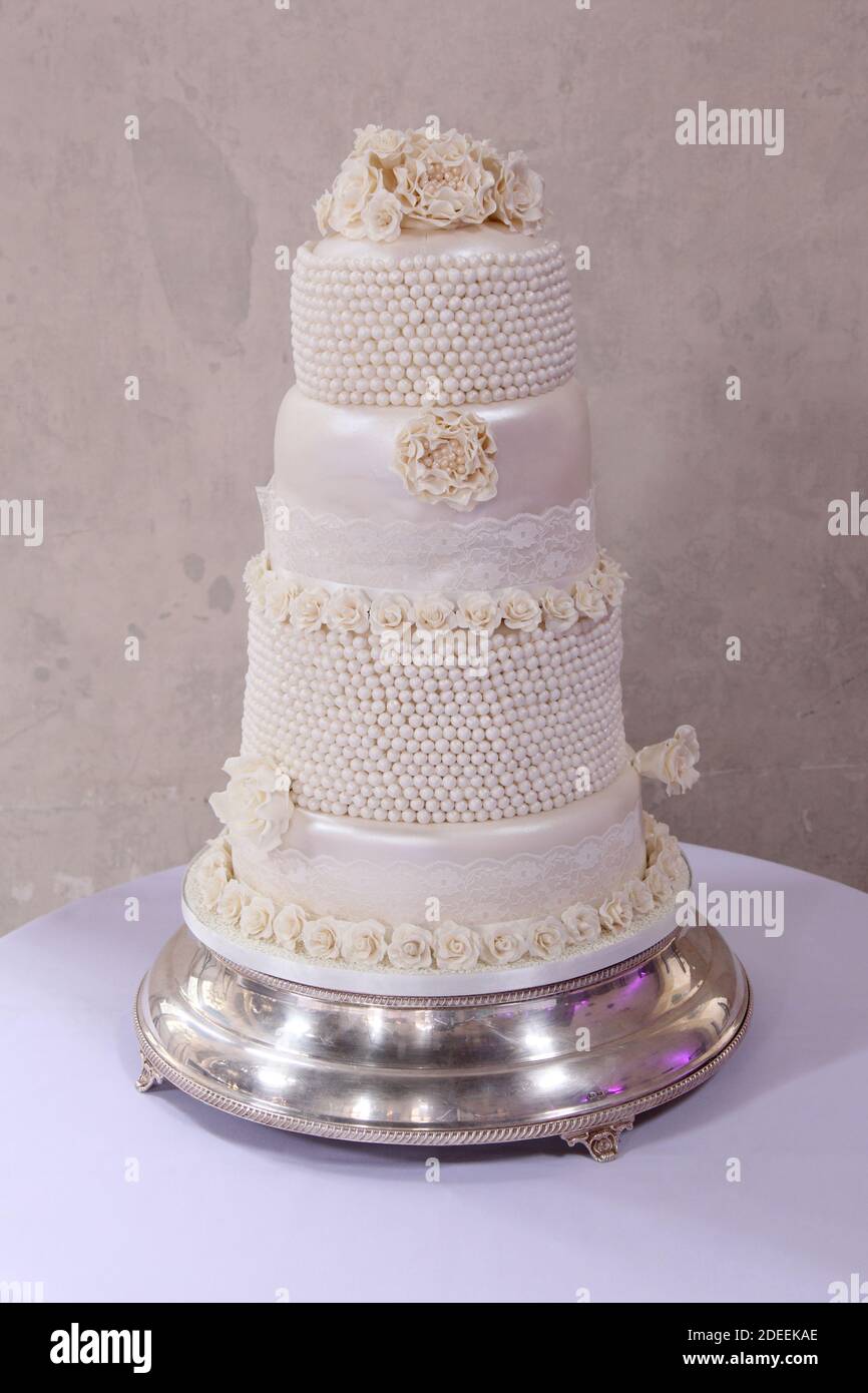 Torta di nozze con fiori di zucchero, panna bianca o avorio a più livelli Foto Stock