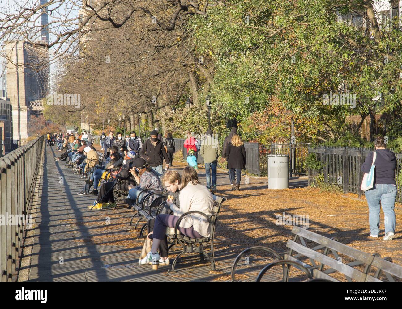 Le persone si rilassano in una soleggiata giornata autunnale lungo la Promenade nel quartiere Brooklyn Heights di Brooklyn, New York. Foto Stock