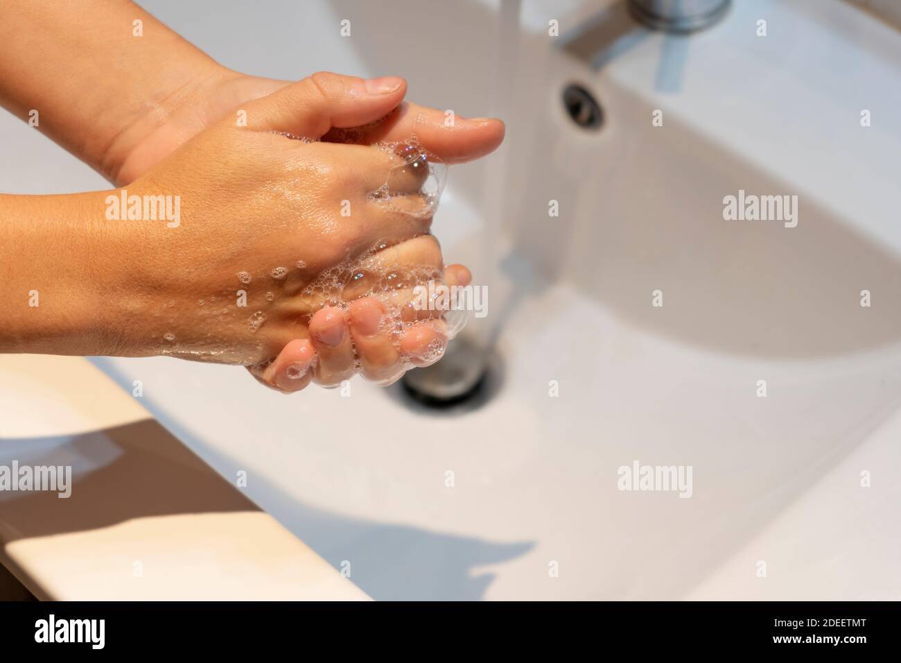 Donna lavando le mani con sapone in concetto sink.Hygiene, protezione preventiva contro germi, coronavirus o covid-19. Foto Stock