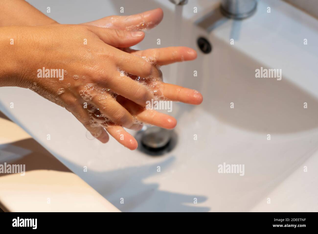 Donna lavando le mani con sapone in concetto sink.Hygiene, protezione preventiva contro germi, coronavirus o covid-19. Foto Stock