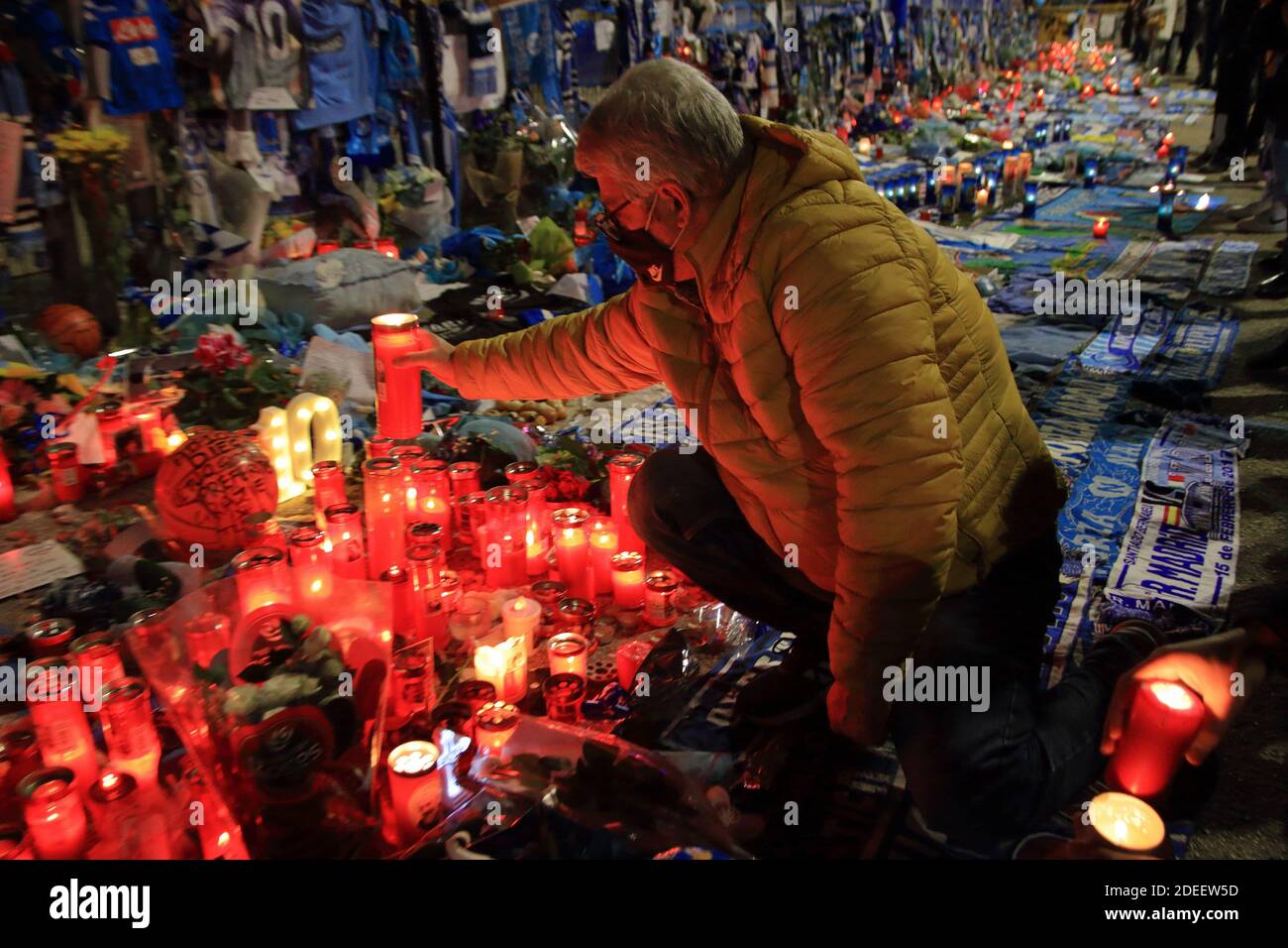 Un fan di Napoli accende una candela, davanti alle porte dello Stadio, in memoria di Diego Armando Maradona , nei giorni successivi alla morte Foto Stock