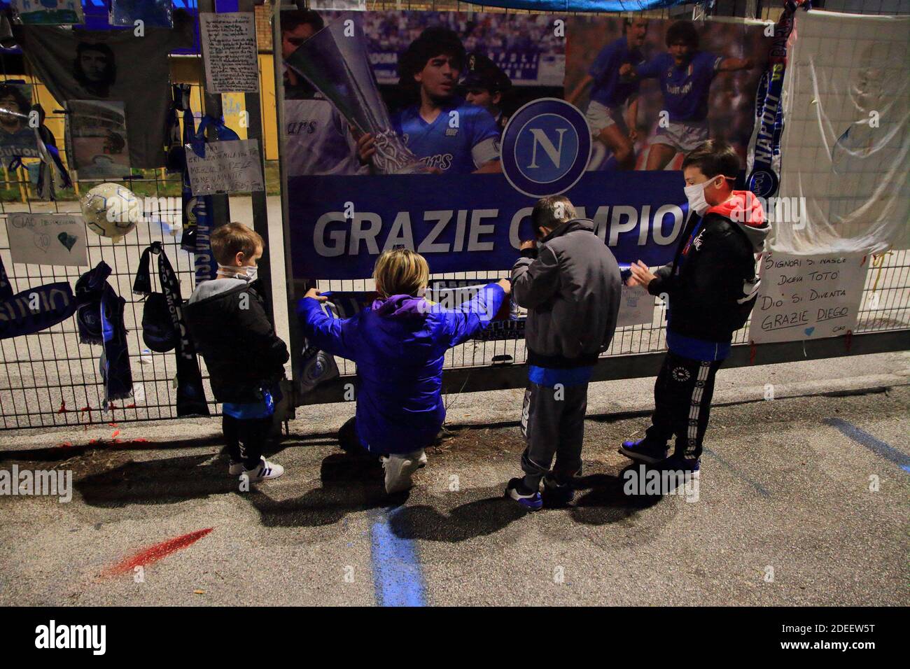 Alcuni bambini hanno messo una sciarpa di Napoli davanti alle porte dello stadio, in memoria di Diego Armando Maradona , nei giorni successivi alla morte Foto Stock