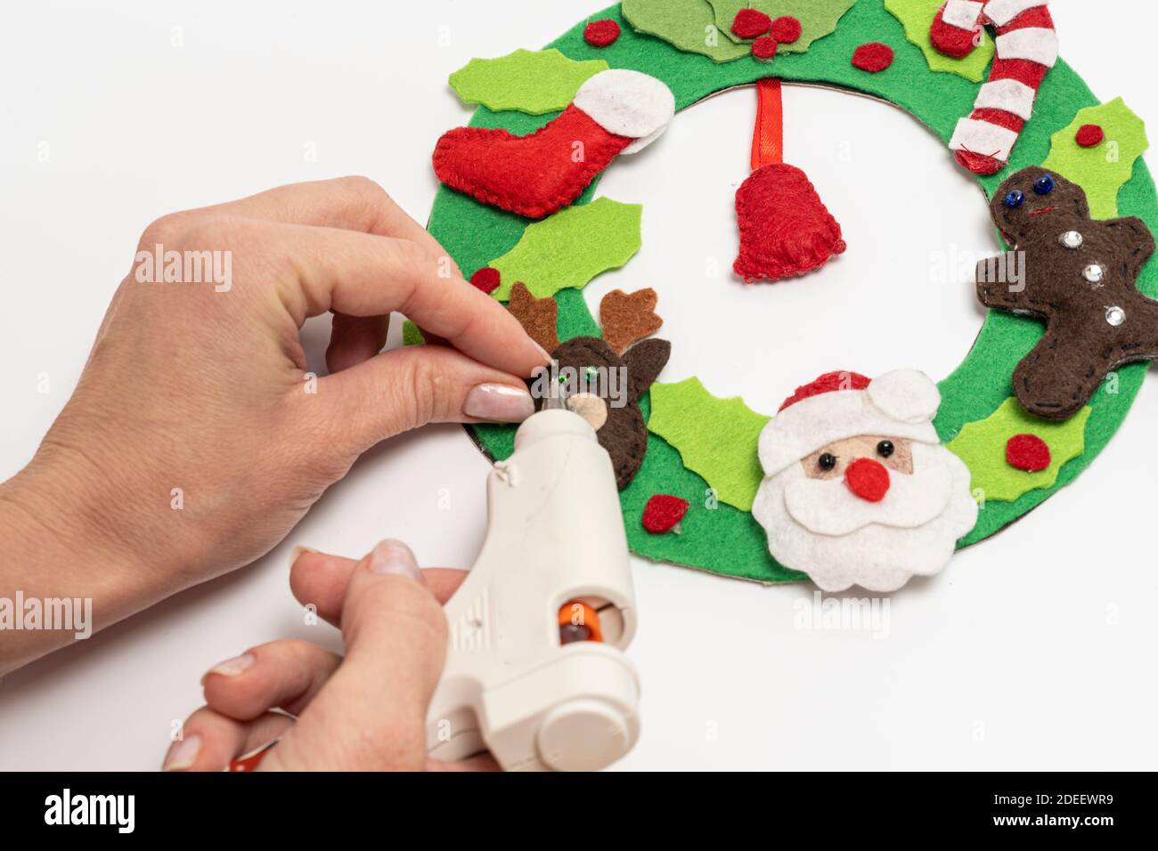 Le mani delle donne con pistola di colla fanno addobbi di Natale fatti in casa. Alta qualità Foto Stock