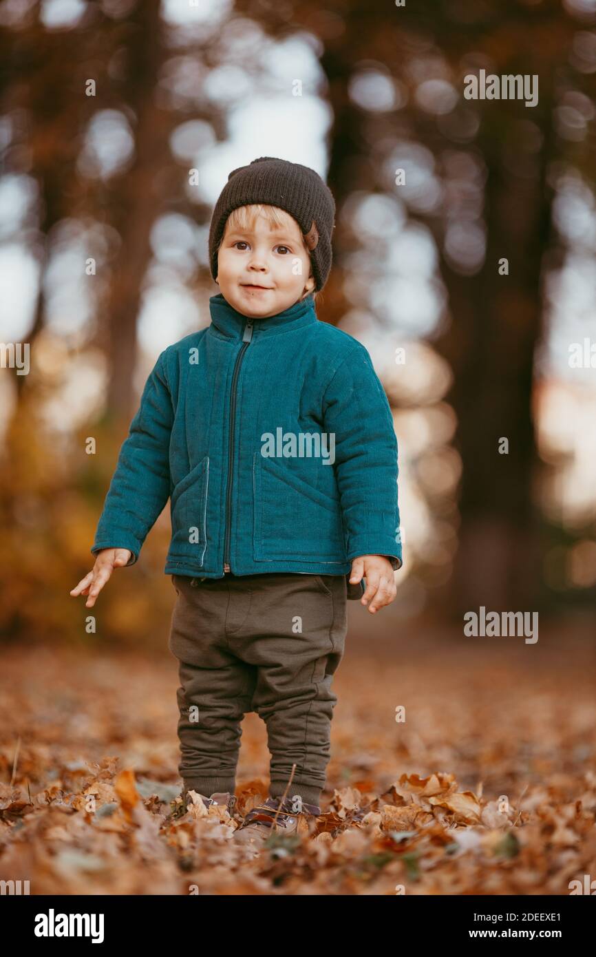 Il bambino felice sta arrivando. Un ragazzo vestito con giacca verde e  pantaloni marroni. Immagine con messa a fuoco selettiva Foto stock - Alamy