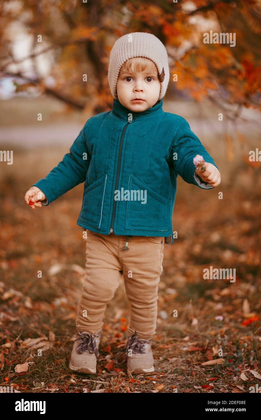 Gioito bambino corre. Un ragazzo vestito con una giacca verde e pantaloni  marroni. Immagine con messa a fuoco selettiva Foto stock - Alamy
