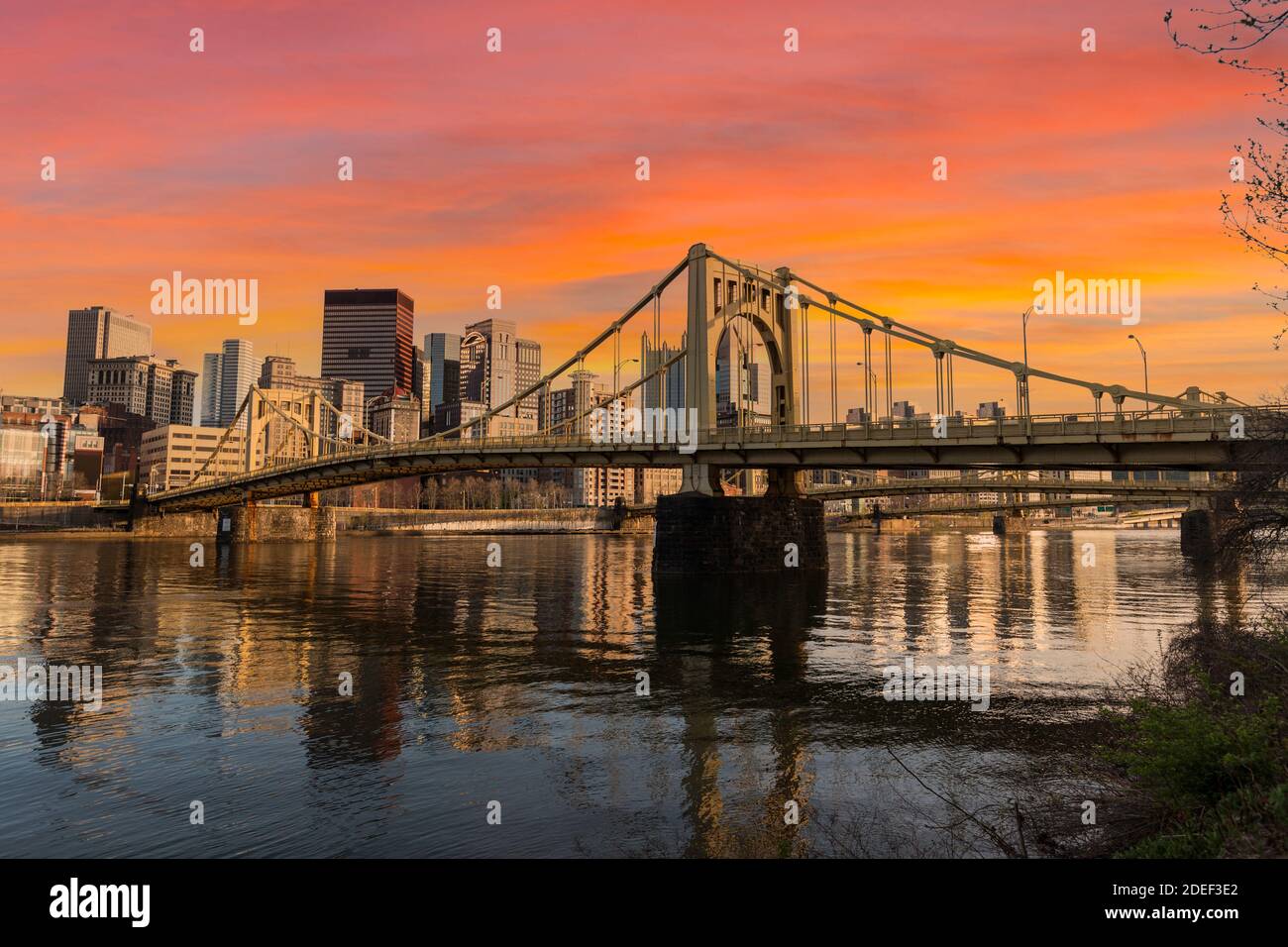 Lungomare urbano e ponti che attraversano il cielo al tramonto nel centro di Pittsburgh, Pennsylvania. Foto Stock