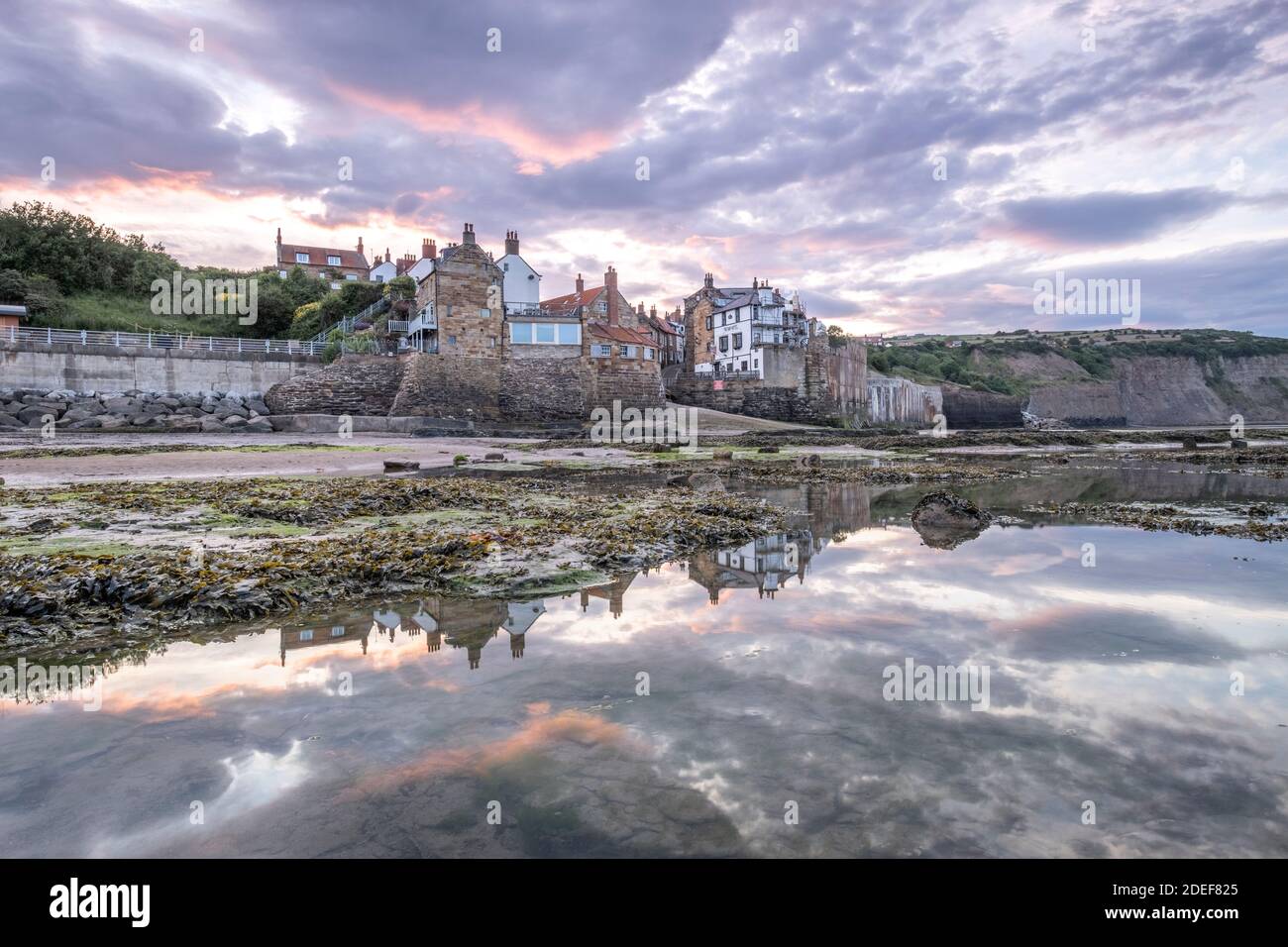 Tramonto sul piccolo villaggio di pescatori di Robin Hoods Bay, North Yorkshire Coast Foto Stock