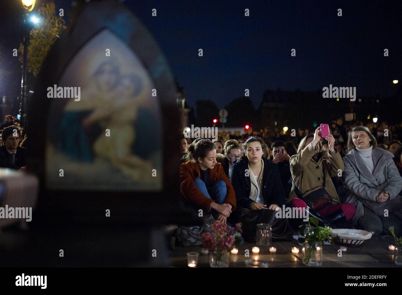 La gente che prega con le candele sul posto saint michel di fronte ad una statua della Vergine Maria durante una serata di preghiera e canzoni organizzate dalla comunità cattolica il giorno dopo Notre Dame brillare con una marcia organizzata dalla chiesa di Saint-Sulpice a Saint Michel e infine accanto a Notre Cattedrale di Dame a Parigi all'inizio del 16 aprile il giorno dopo l'inizio del fuoco, 2019. Un enorme incendio che devastò la cattedrale di Notre-Dame è "sotto controllo", ha detto la brigata di Parigi all'inizio del 16 aprile, dopo che i vigili del fuoco passarono ore a combattere le fiamme. Foto di Raphael Lafargue/ABACAPRESS.COM Foto Stock