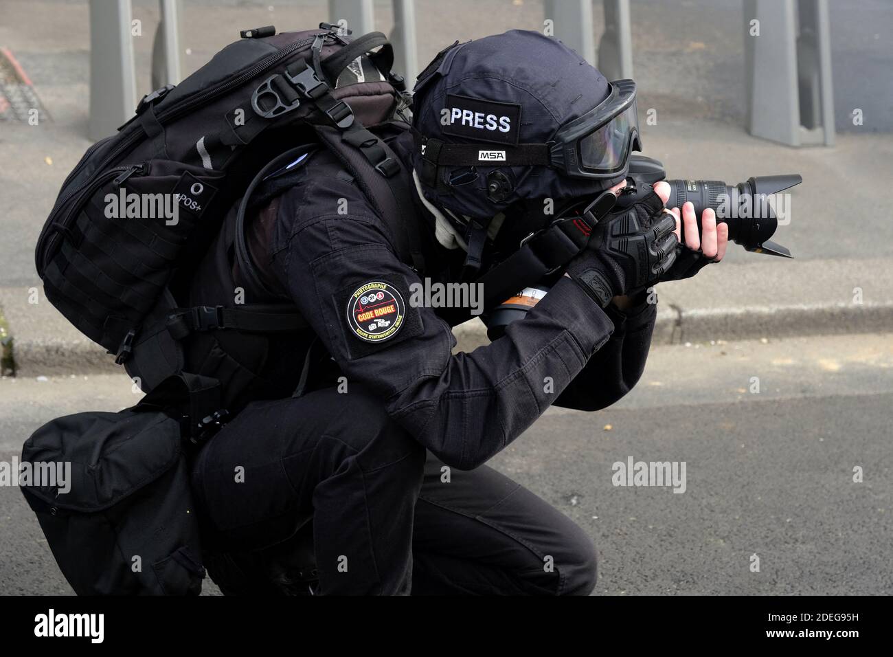 Un fotografo della stampa che scatta fotografie, indossando casco e  maschera a gas, coprendo la rivolta dei giubbotti gialli (giletti jaunes)  movimento, violenza si è verificato nelle strade di Parigi, scontri  scoppiati