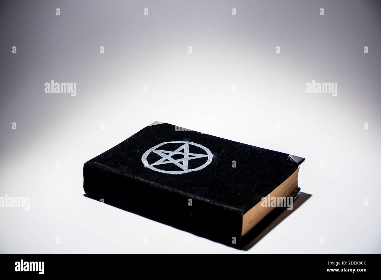 Grimoire occulto, libro di magia nero su sfondo bianco spazio di copia vuoto. Foto Stock