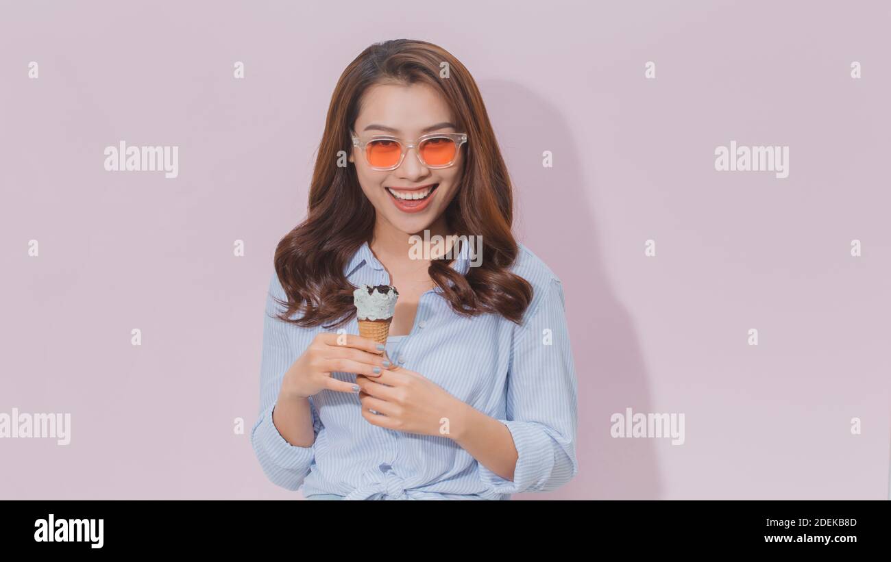 Allegro ragazza a mangiare il gelato cono Foto Stock