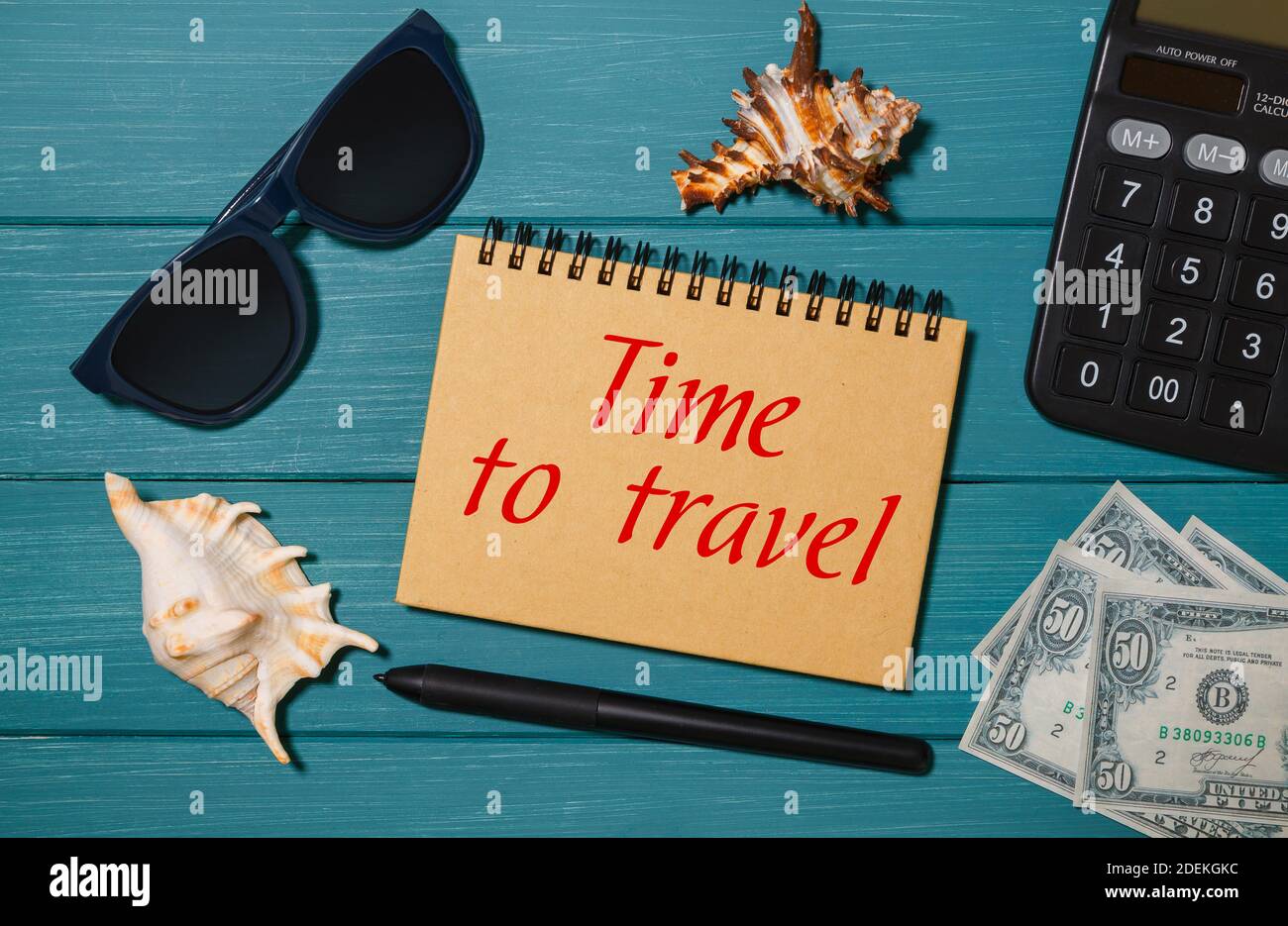 Craft notebook con le parole Time to Travel, occhiali, denaro, calcolatrice e conchiglie Foto Stock