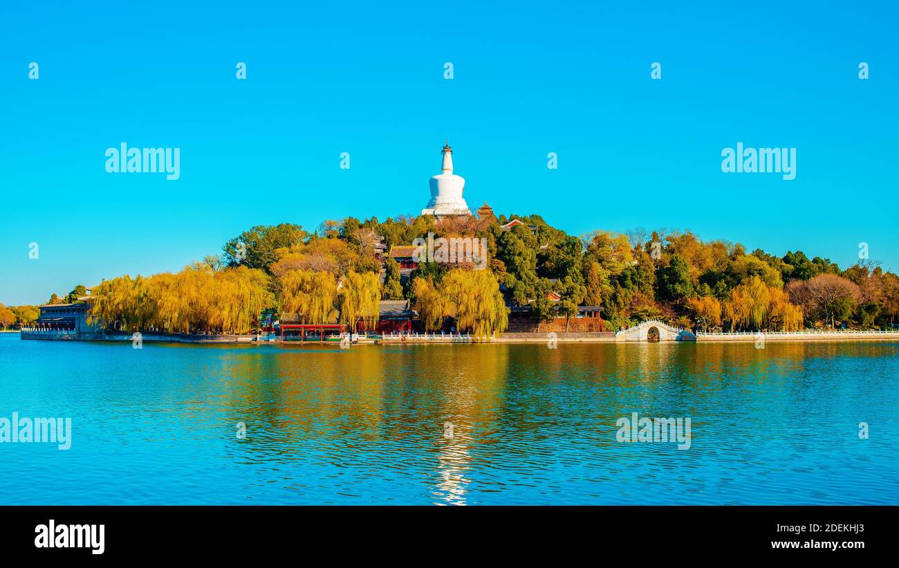 Splendida vista sul lago Beihai e sull'isola di Jade con la Pagoda Bianca nel Parco Beihai. Asia, Cina, Pechino città. Giorno di sole, cielo blu chiaro. Stagione autunnale. Foto Stock