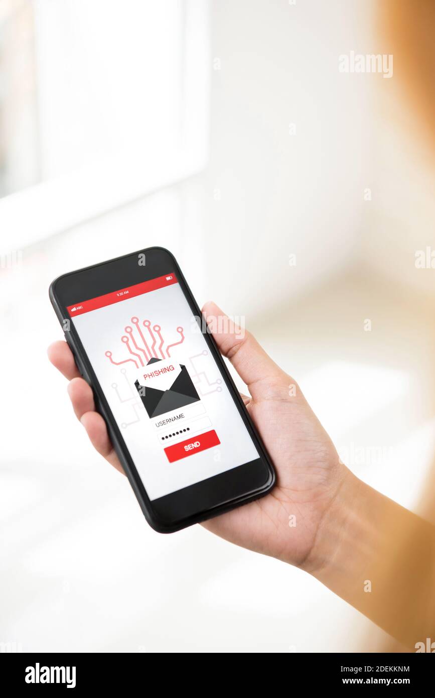 L'utente che guarda lo schermo dello smartphone considerando prima di inviare indietro sensibile informazioni per truffare e-mail di phishing Foto Stock