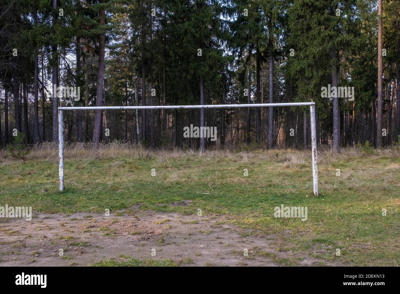 Obiettivo di calcio fatto di tubi in metallo bianco su un campo da gioco foresta in un giorno di autunno. Foto Stock