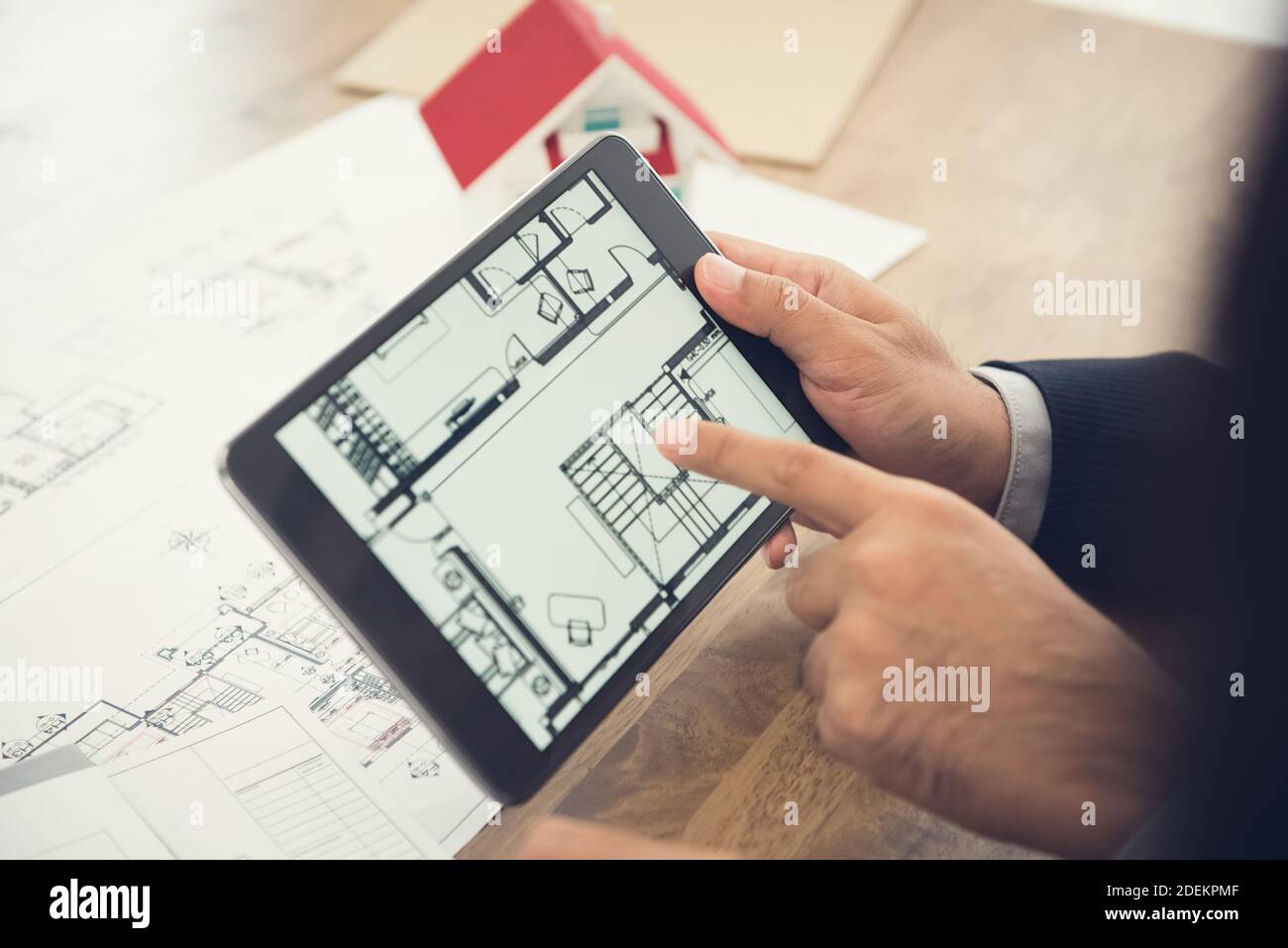 Agente immobiliare o architetto che presenta la pianta della casa a. client sullo schermo del computer tablet Foto Stock
