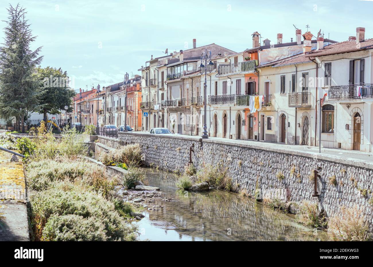 Paesaggio urbano con vecchie case sul lungofiume del fiume Givenco, girato in luce brillante a Pescina, l'Aquila, Abruzzo, Italia Foto Stock