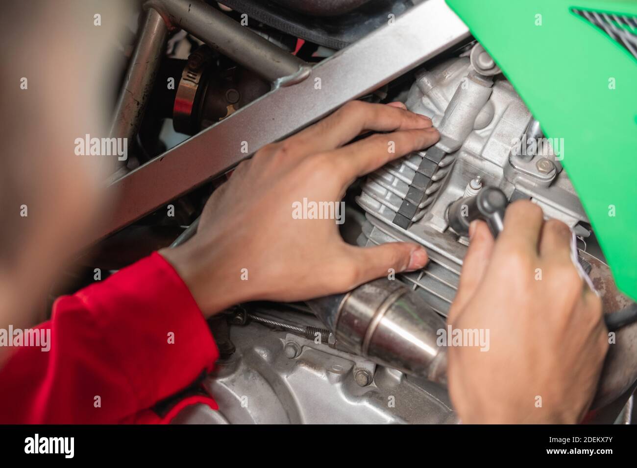 primo piano del meccanico che fissa un cavo delle candele garage Foto Stock