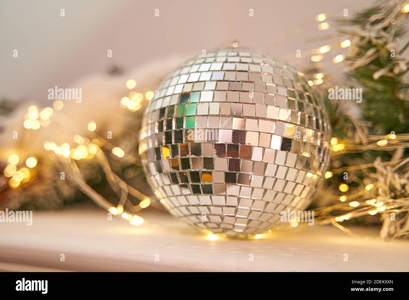 Discoteca Mirror Ball con decorazioni di Capodanno giace su a. camino bianco Foto Stock