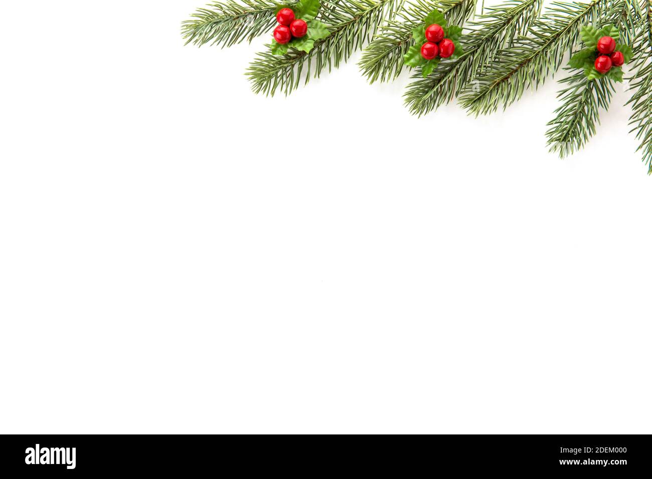 Natale e Capodanno sfondo vista dall'alto bordo design con pino verde, mistetoe, bacche rosse e spazio copia su sfondo bianco Foto Stock