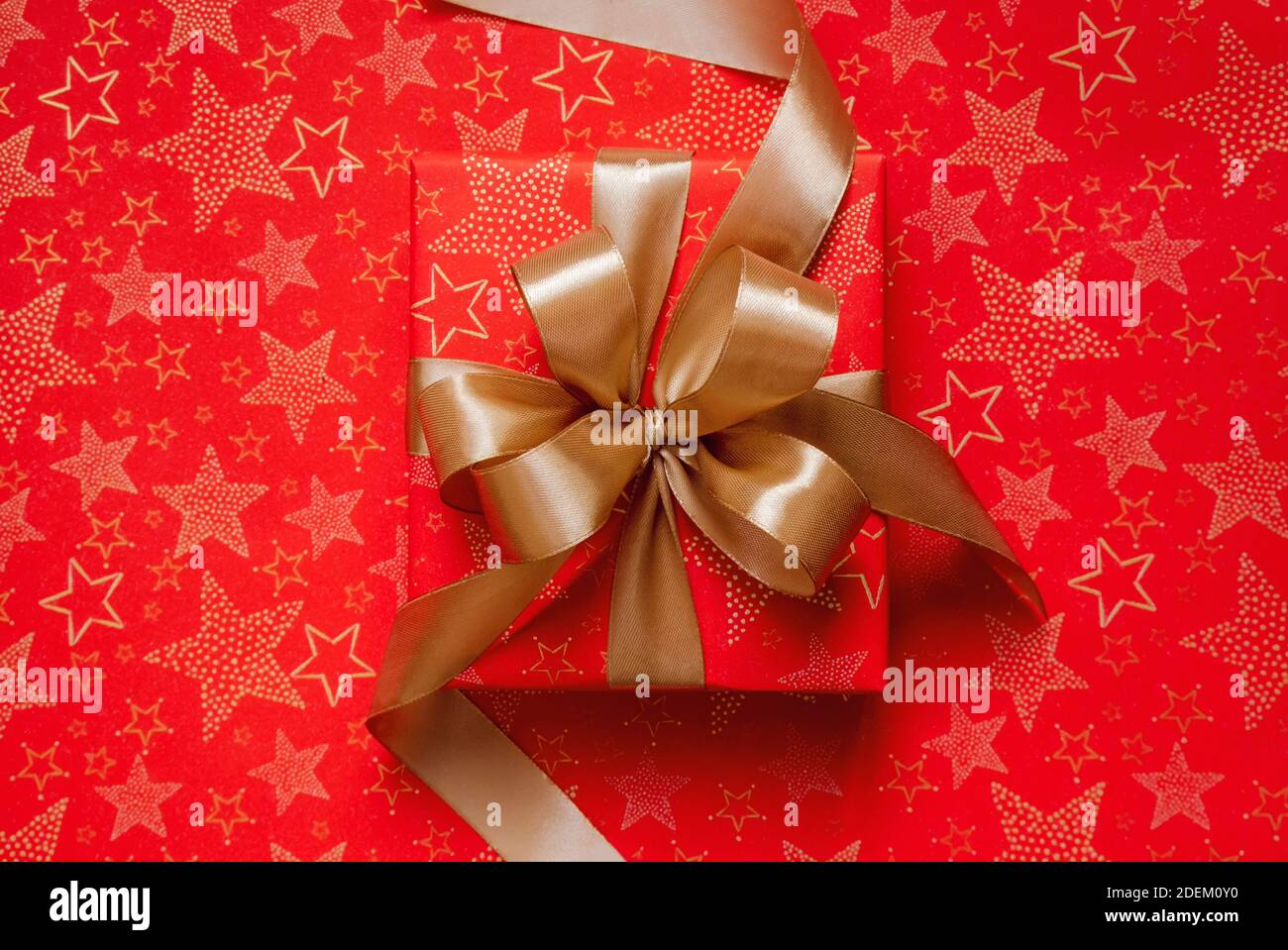 Regalo di Natale rosso con nastro d'oro e arco sopra Foto Stock