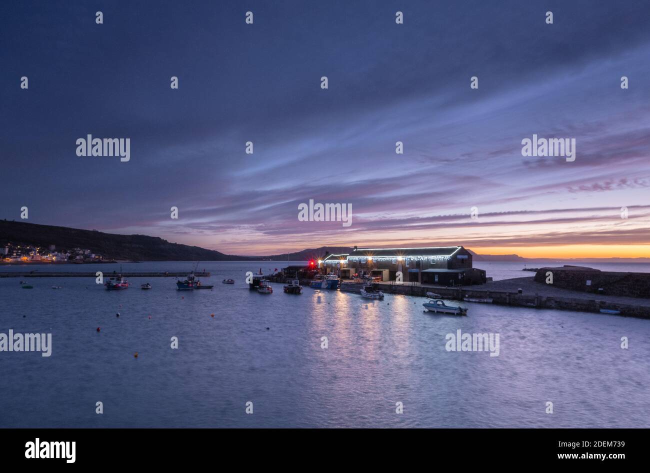 Lyme Regis, Dorset, Regno Unito. 1 dicembre 2020. UK Weather: Beautiful Dawn Colors over storico Cobb come dicembre si spegne a un freddo e inverno di inizio. Le risme si illuminano lungo il Cobb brillano con la stagione natalizia in corso. Credit: Celia McMahon/Alamy Live News Foto Stock