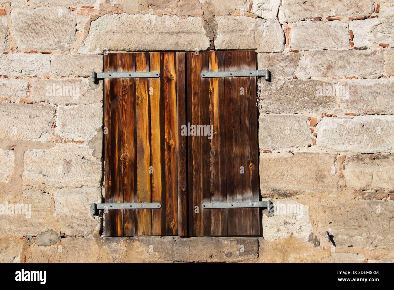 Antico serramento in legno d'epoca e parete in pietra naturale Foto Stock