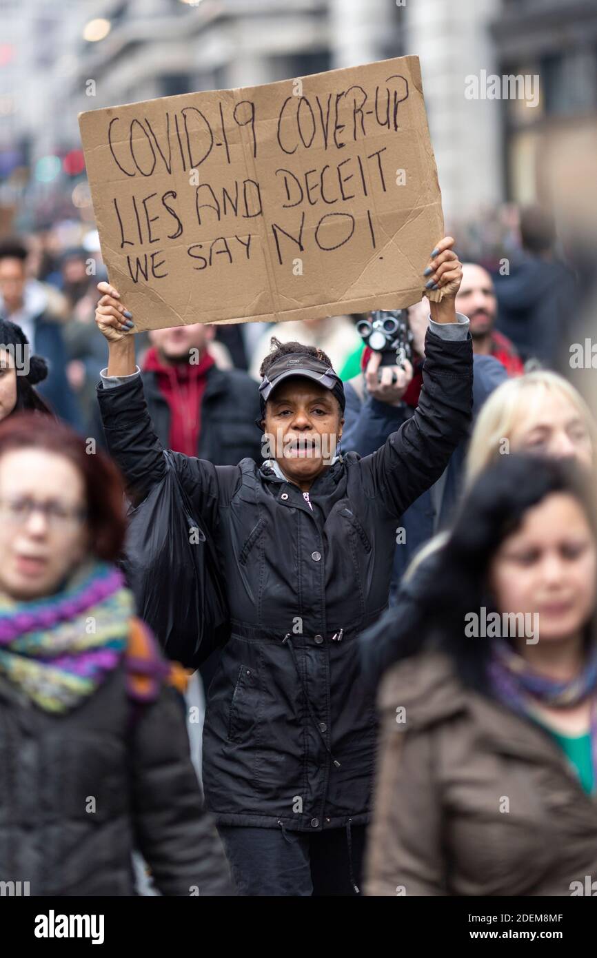 Protesta anti-lock-down, Londra, 28 novembre 2020. Una donna nera che marciava e tiene un cartello di protesta sopra la testa. Foto Stock