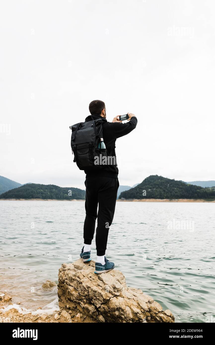 Giovane uomo natura esploratore godendo la vista della montagna lago Foto Stock