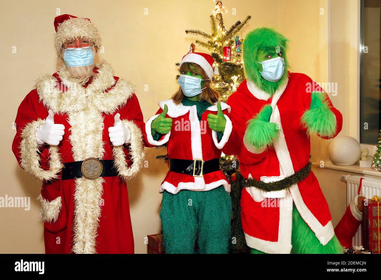 Babbo Natale convinse il Grinch e la signora Grinch a indossare una maschera protettiva. GEEK ART - Bodypainting e Transformaking: 'Il Grinch ruba Natale' fotografare con Enrico Lein come Grinch, Maria Skupin come Sig.ra Grinch e Fabian Zesiger come Babbo Natale a Villa Czarnecki ad Hameln il 30 novembre 2020 - un progetto del fotografo Tschiponnique Skupin e del bodypainter Enrico Lein Foto Stock