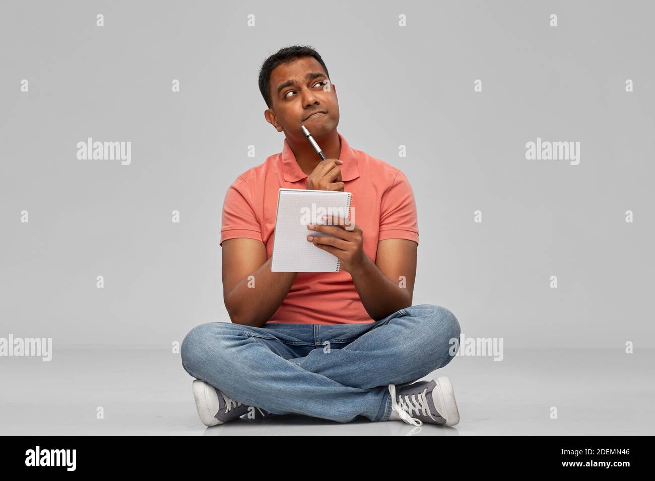uomo indiano in polo con taccuino e penna Foto Stock