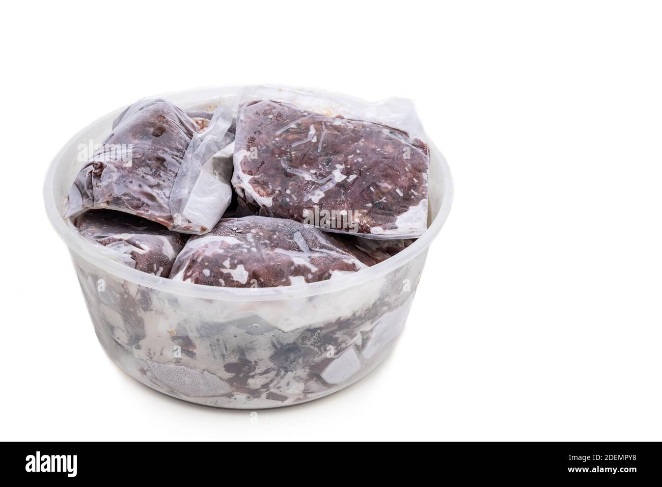 Cibo crudo di barbano sminuzzato fatto in casa per cani confezionato e congelato nella taglia di servire per la conservazione. Foto Stock