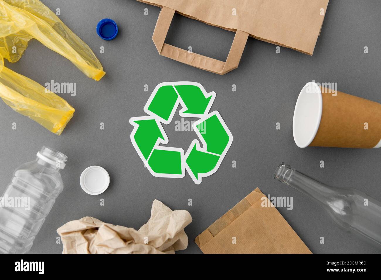 simbolo di riciclaggio verde con rifiuti domestici in grigio Foto Stock