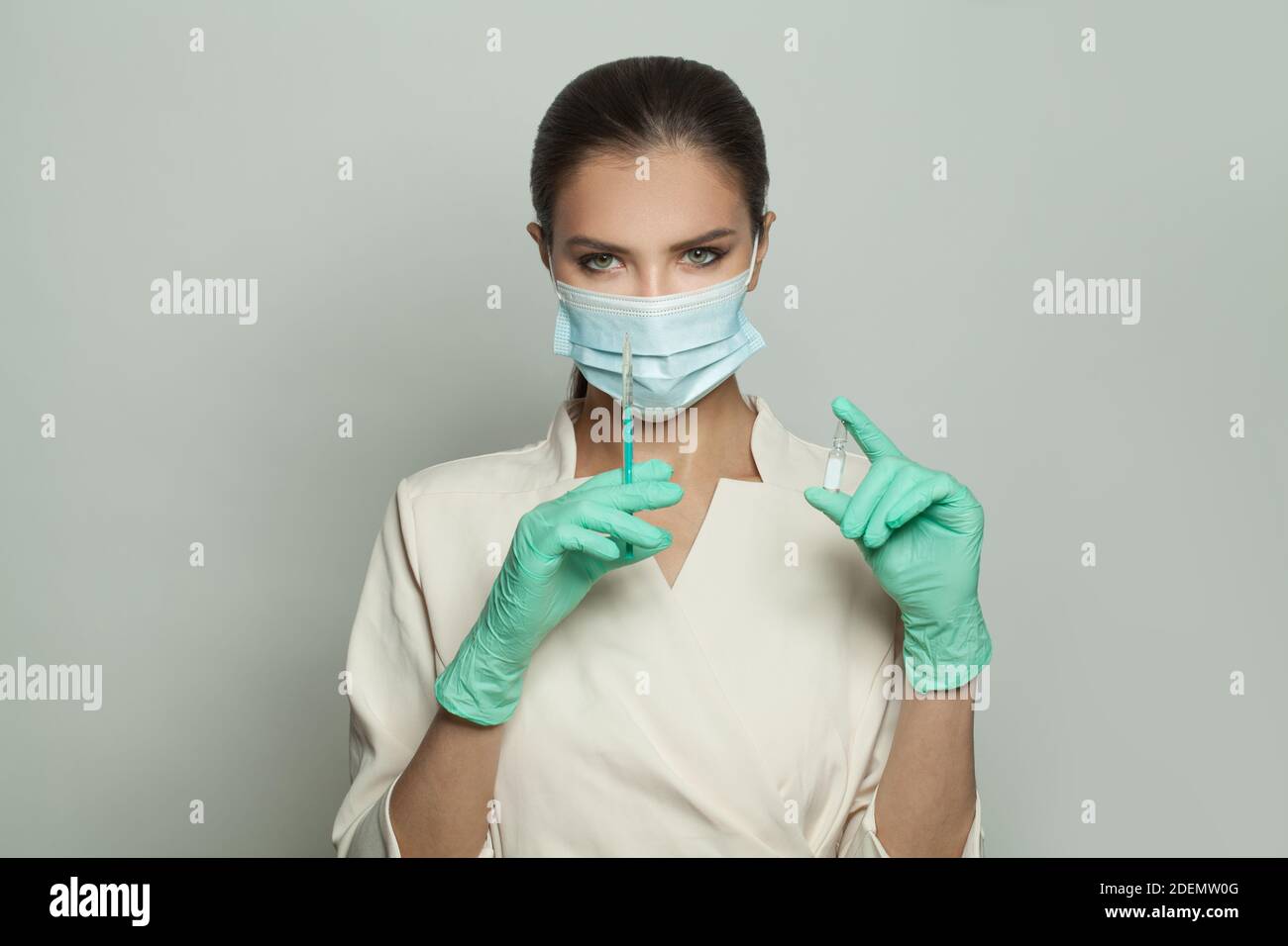 Medico intelligente o infermiere in uniforme professionale con siringa e ampolla su sfondo bianco. Medicina, cosmetologia e concetto di vaccinazione Foto Stock