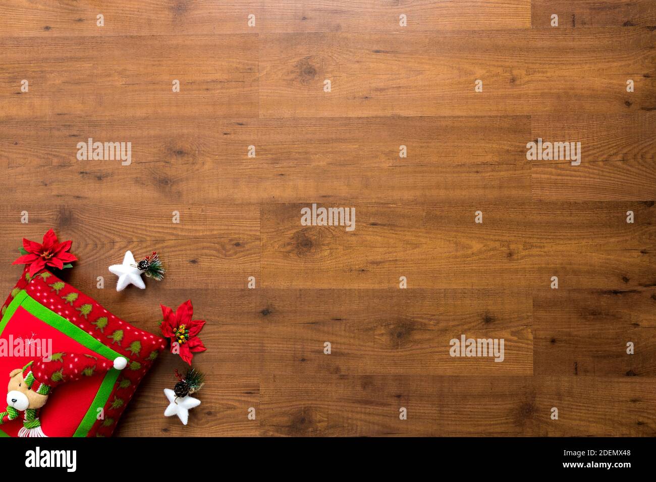 Ornamenti natalizi tra cui cuscino, regali, stelle e palle su sfondo di legno Foto Stock