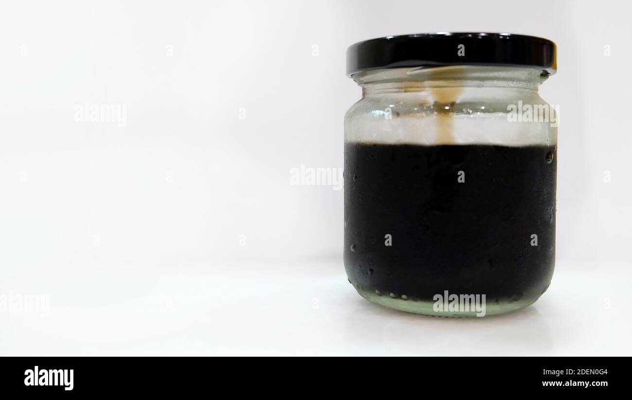 Un vaso di vetro con coperchio e una gelatina nera all'interno del vaso. Foto Stock