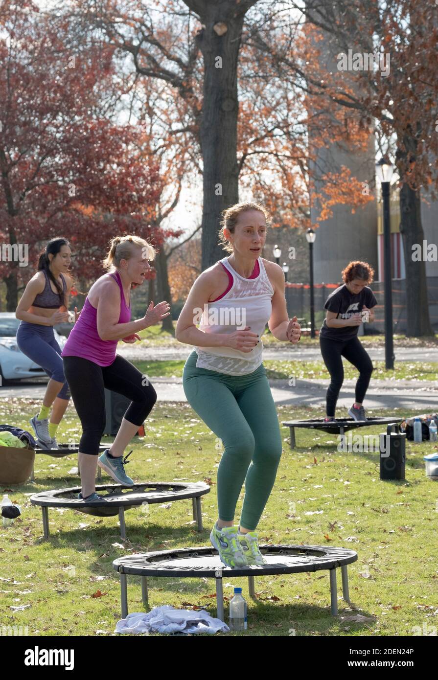 Donne in una classe Urban Rebounding ballando mentre su un trampolino piccolo. Nel Flushing Meadows Corona Park a Queens, New York City. Foto Stock