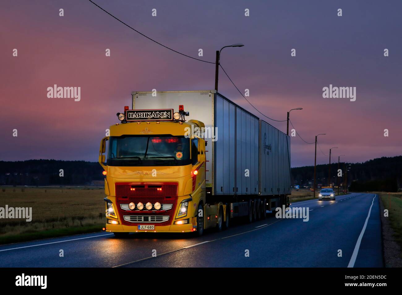 Splendidamente personalizzato, il giallo Volvo FH16 di TransHartikainen Ky tira il rimorchio al tramonto d'inverno sulla strada statale 52. Salo, Finlandia. 26 novembre 2020. Foto Stock