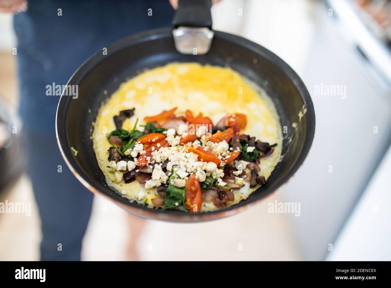 Omelette di funghi, pomodoro e formaggio su una padella Foto Stock