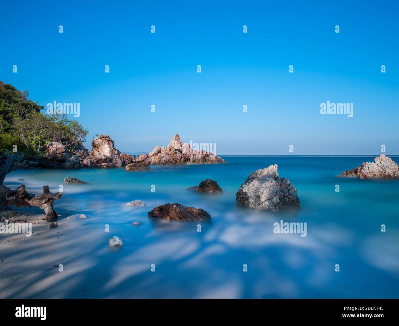 Serie di shell in luce e ombra su un bianco spiaggia di sabbia natura art design con lunga esposizione Foto Stock