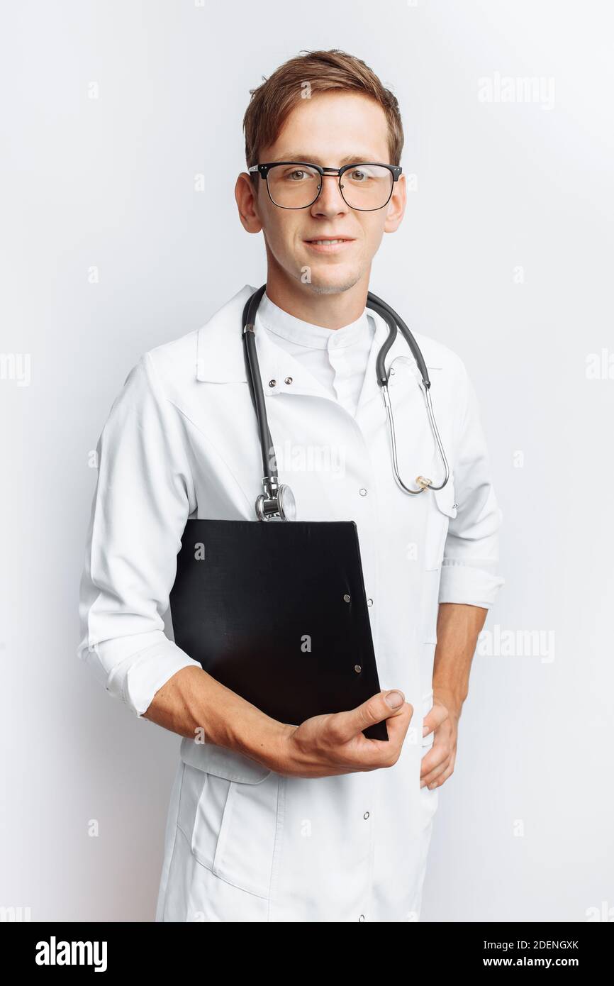 Medico giovane e bello, studente interno con cartella in mano, sfondo bianco, Foto Stock