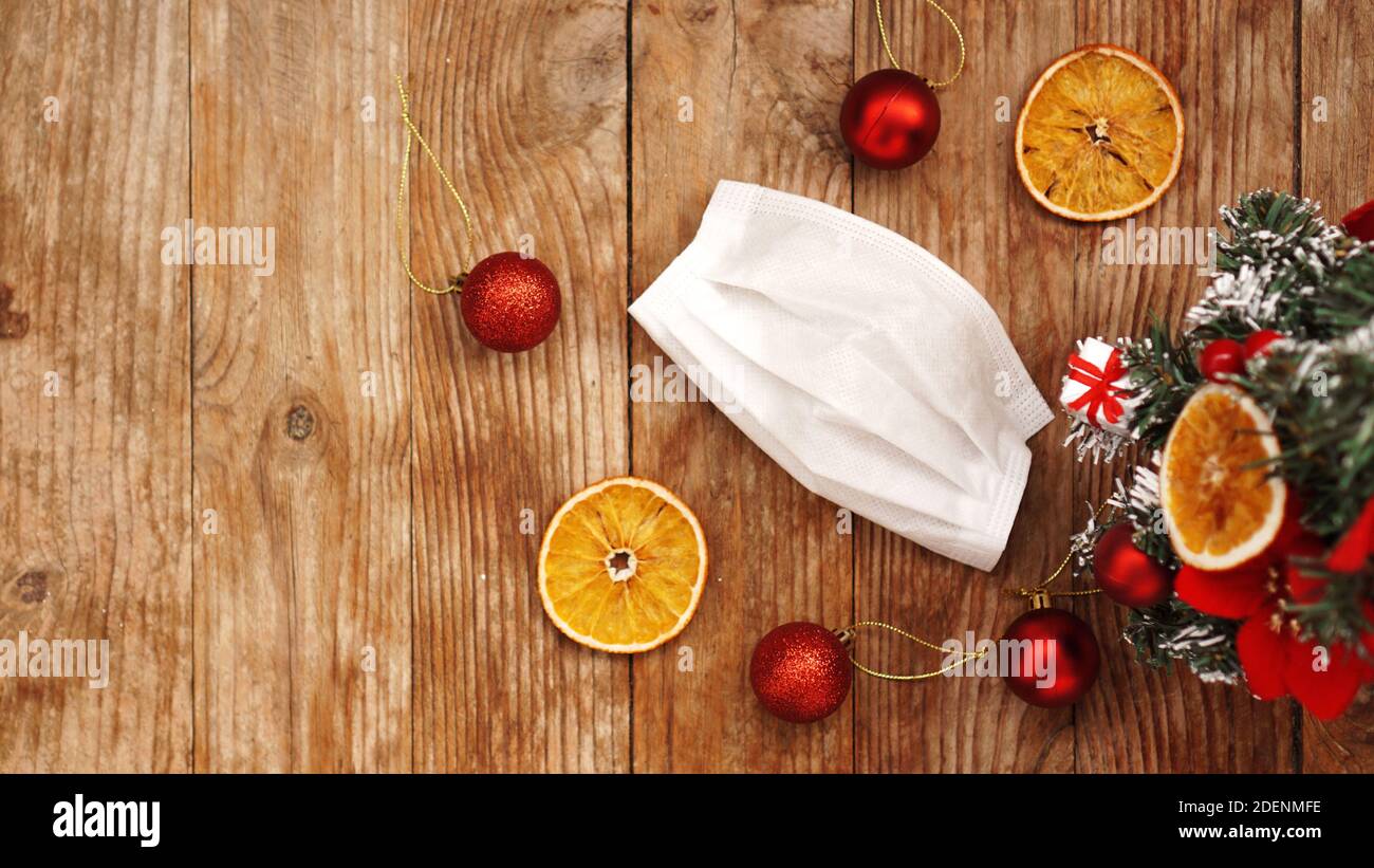 Medicina di natale. Concetto di nuovo anno durante il periodo del coronavirus covid-19. Vista dall'alto della maschera protettiva e dell'albero di Natale su sfondo di legno. Foto Stock