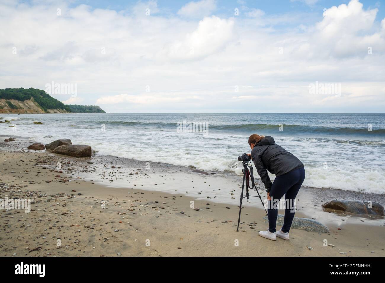 Fotografo irriconoscibile che scatta mare ondulato Foto Stock