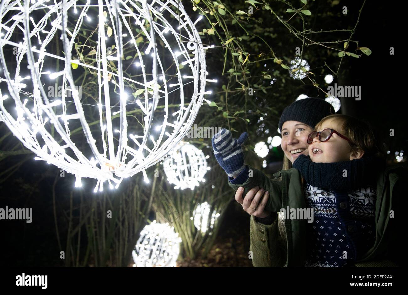 Maria del Pilar Mira Ponton e suo figlio Alfred Alejandro Dudely-Mira, di 3 anni, guardano una lanterna appesa ad un albero, durante un'anteprima per 'Natale a Kew' ai Royal Botanic Gardens a Kew, Londra. Foto Stock