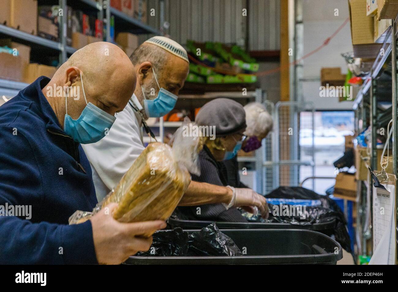 Toronto, Canada. 25 Nov 2020. I volontari che indossano maschere preparano i pasti alla Chasdei Kaduri Jewish Food Bank. E' l'unica organizzazione ebraica che e' pienamente gestita da volontari, dedicata a fornire settimanalmente cibo non deperibile, prodotti da forno freschi e prodotti a centinaia di famiglie ebraiche bisognose nella zona di Toronto. Dalla pandemia di covid-19 nel marzo 2020, la domanda per il loro servizio è aumentata notevolmente. Credit: Shawn Goldberg/SOPA Images/ZUMA Wire/Alamy Live News Foto Stock