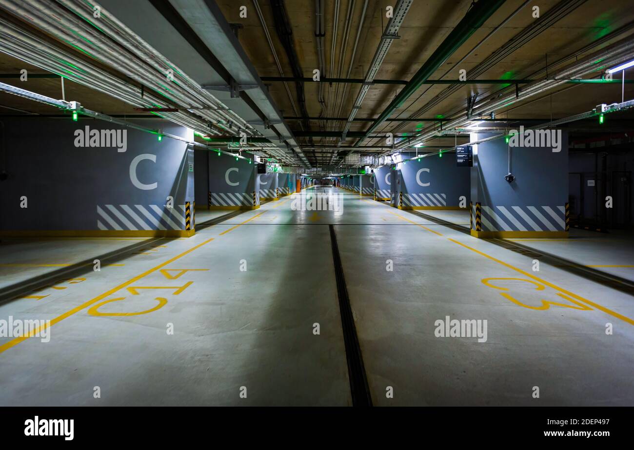 Parcheggio sotterraneo vuoto del centro commerciale o garage interno con colonne dipinte a strisce di cemento. Foto di alta qualità Foto Stock