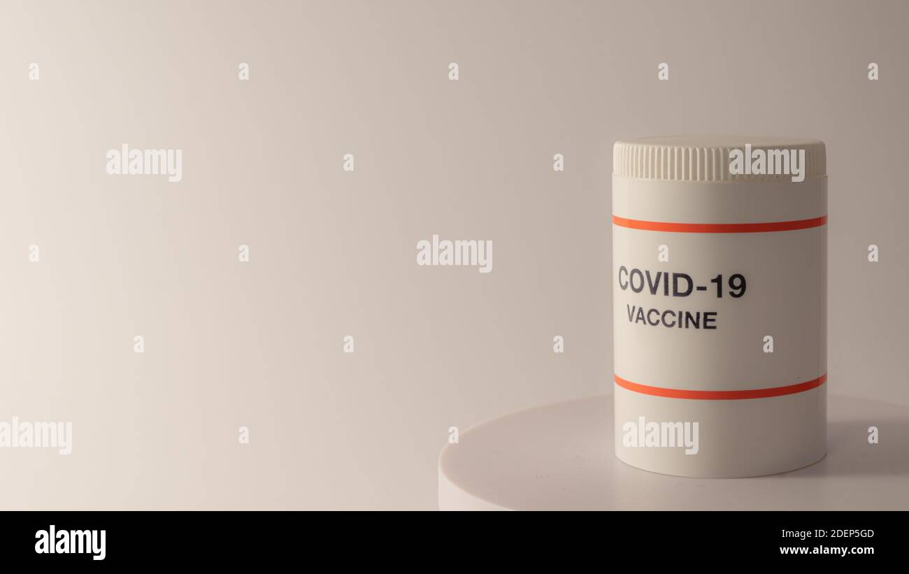 Vaso di plastica bianco con vaccino del coronavirus su un tavolo rotondo con fondo bianco e spazio per copia, Danimarca, 1 dicembre 2020 Foto Stock