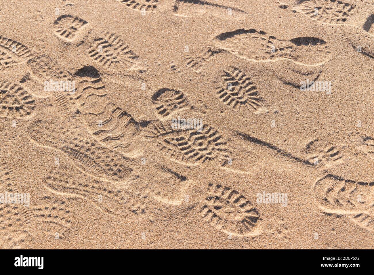 Impronte in sabbia bagnata sulla spiaggia, sfondo foto texture Foto Stock