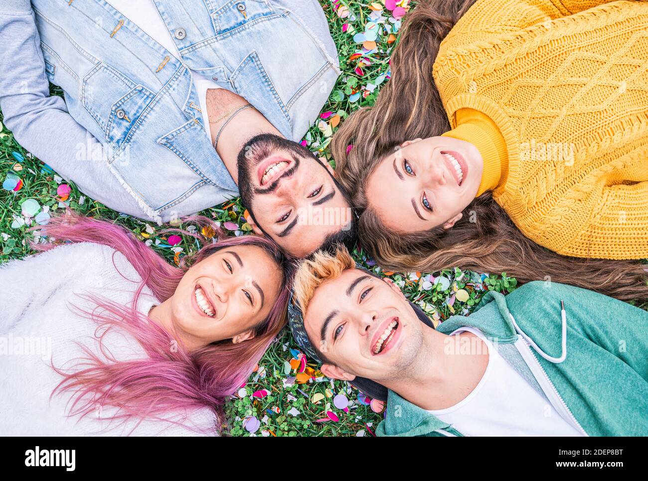 Felici i giovani sorridenti che prendono selfie guardando nel cielo Adagiato sull'erba al parco - concetto di amicizia felice con i giovani studenti che hanno divertimento toge Foto Stock